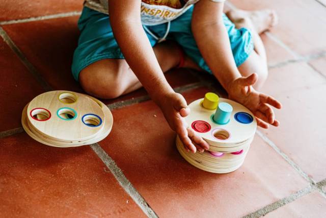 Niño divirtiéndose con un juego educativo de madera