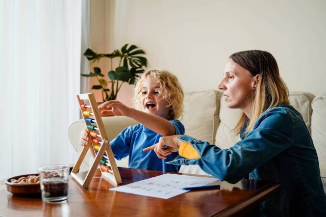 Mother and son learning math with abacus at home