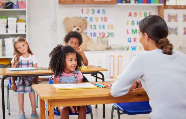 Young woman teaching a class of preschool children