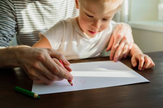 Father teaching child to write or draw