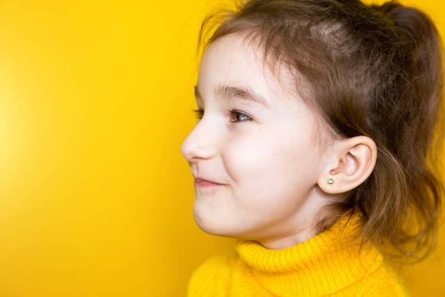 Girl side view on yellow background
