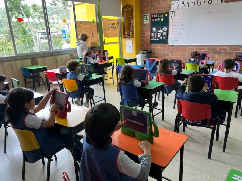 Crianças a utilizar o Magrid em tablets numa sala de aula do ensino básico